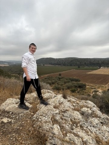 My son standing on limestone rocks above the valley fields