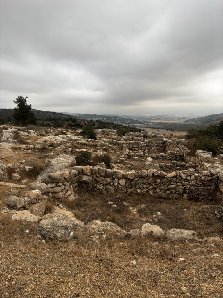 The stone foundations of the ancient city at Khirbet Qiyafa under a grey sky